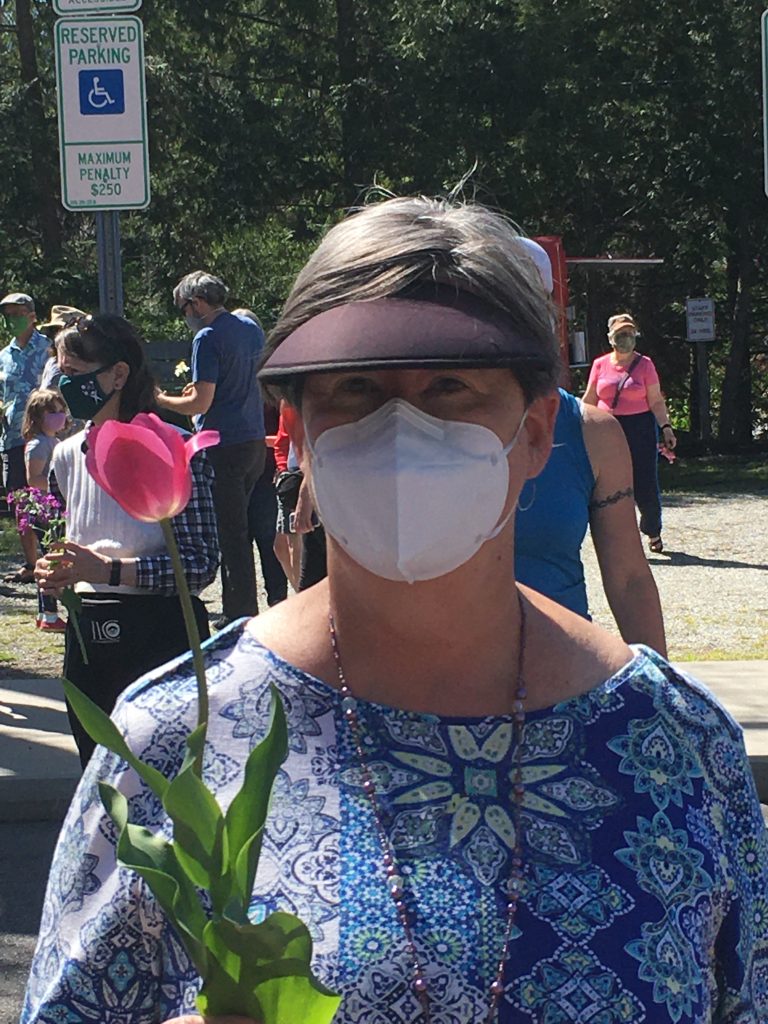 Masked woman holding flower