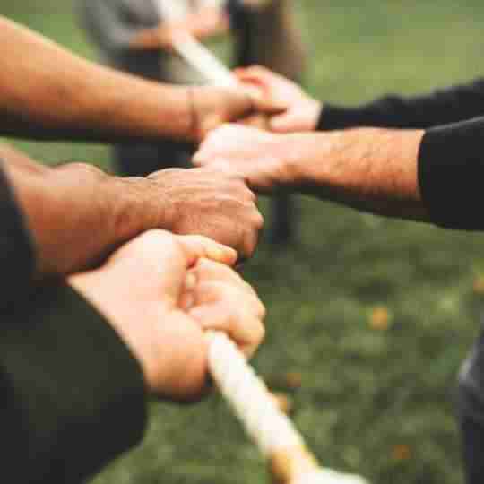 Image of a group playing tog of war in the park 