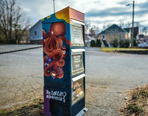 Photo of mailbox-size street pantry adopted by UU Asheville.  Side painting is of a red octopus.